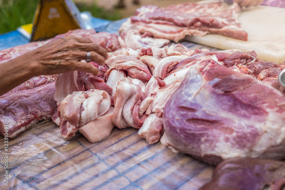 hand choosing pork in the market