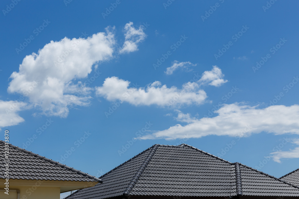 black tile roof on house with clear blue sky and cloud black tile roof on house with clear blue sky and cloud