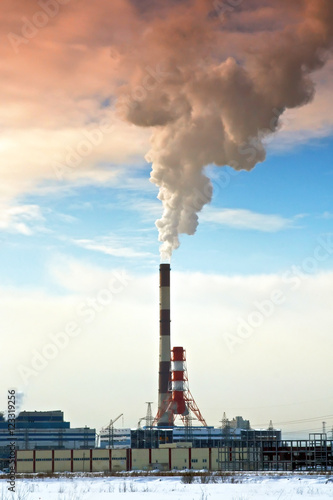 Pipes of thermal power station. Steam and smoke. Industrial factory landscape.