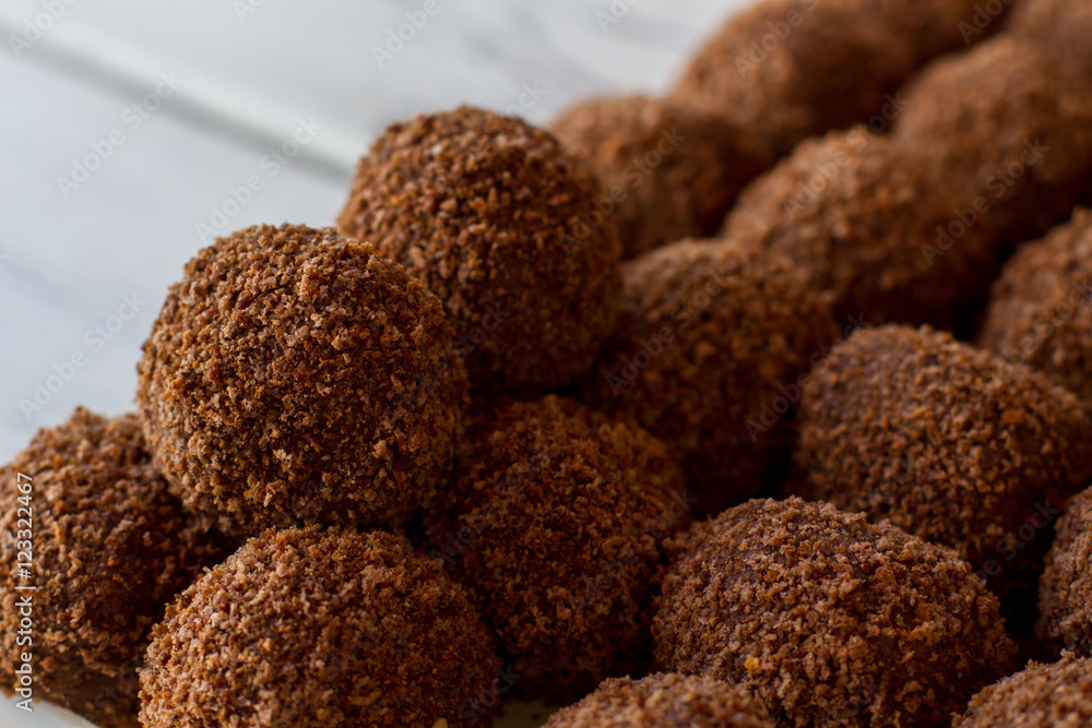 Dark ball shaped sweets. Lots of brown candies. Traditional russian dessert. Butter and crumbled biscuits. Dark ball shaped sweets. Lots of brown candies. Traditional russian dessert. Butter and crumbled biscuits.