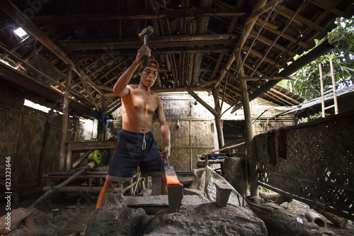 Mature man making a sword photo