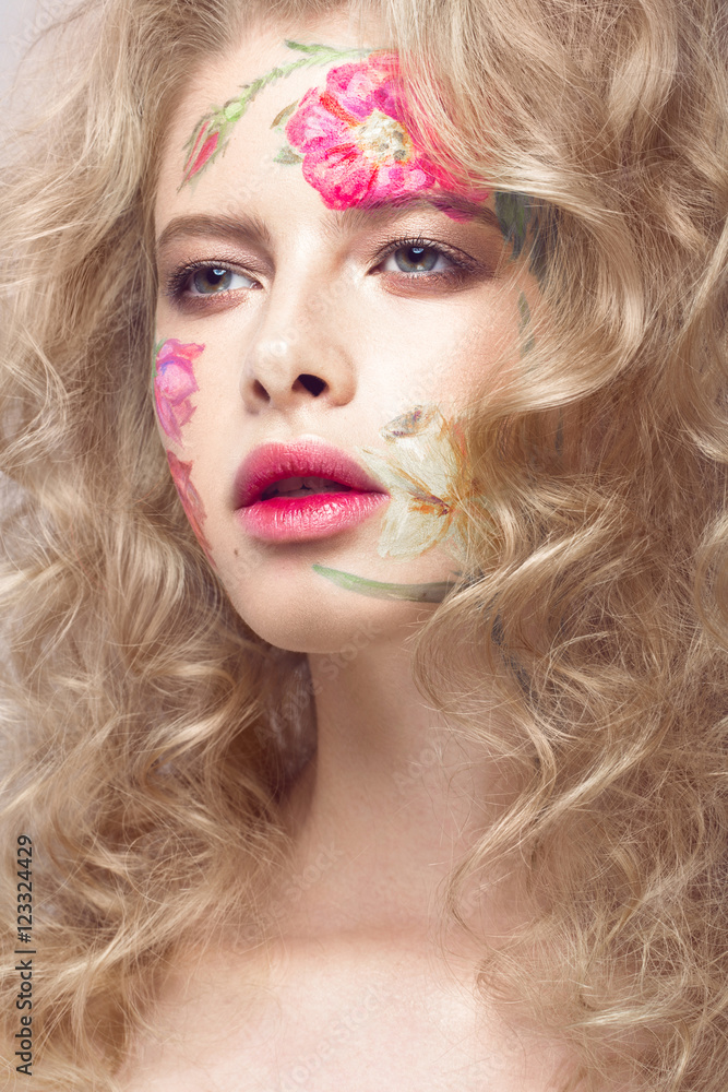 Beautiful blond girl with tresses and a floral pattern on the face. Beauty flowers. Portrait shot in studio Beautiful blond girl with tresses and a floral pattern on the face. Beauty flowers. Portrait shot in studio