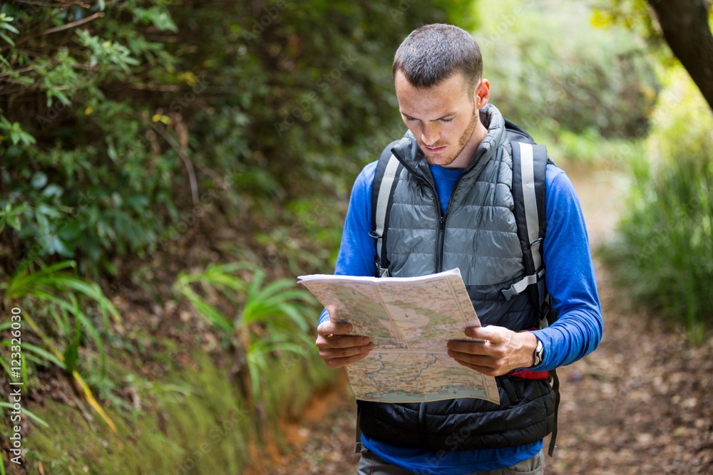 Fototapeta premium Male hiker looking at map