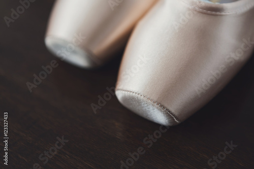 Pink ballet pointe shoes closeup on dark wood background