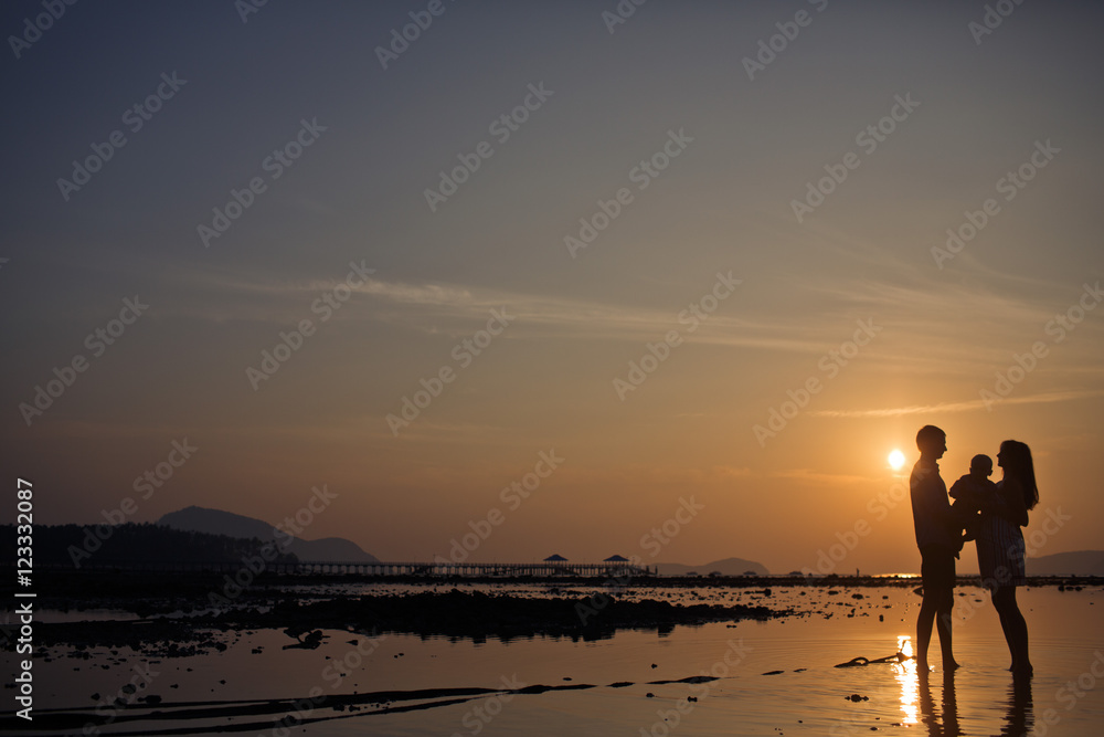 The parents with son look at sunset