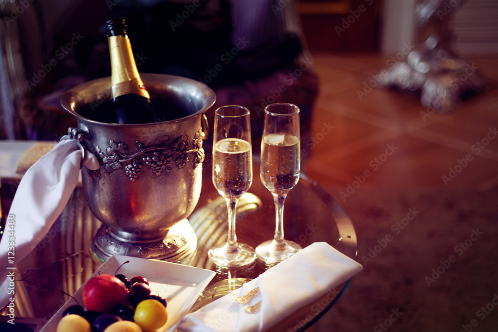 Still life, romantic dinner, two glasses and champagne in the ice bucket. Celebration or holiday