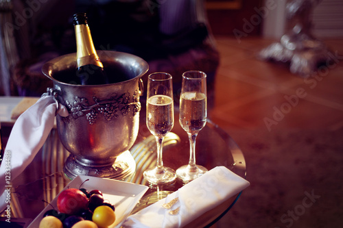 Still life  romantic dinner  two glasses and champagne in the ice bucket. Celebration or holiday