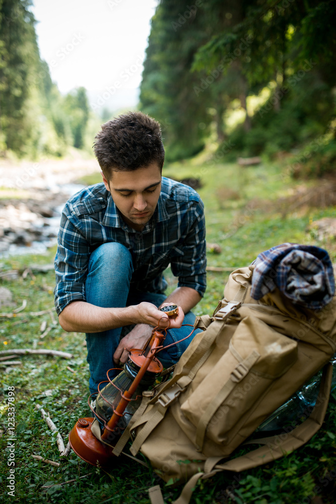 Fototapeta premium Traveler young man of searching direction with a compass in summer outdoor.