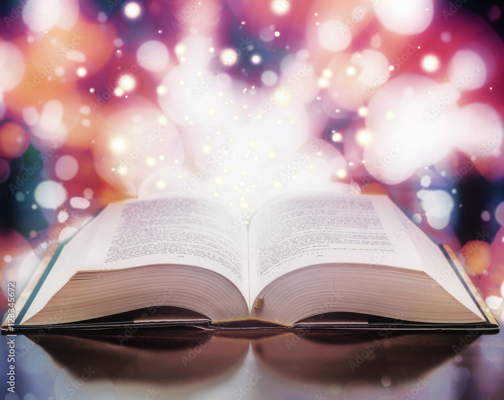 Open book with light particles Open book with light particles