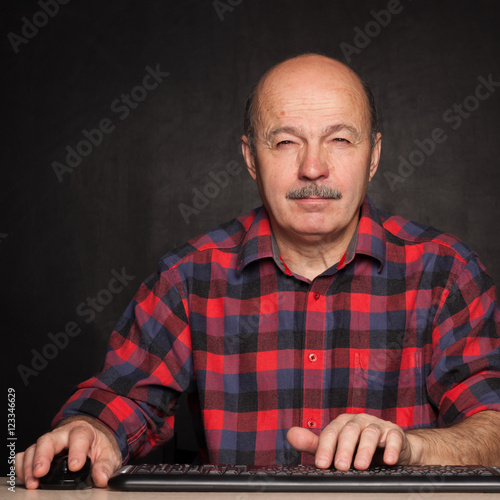 man in a white shirt works at the computer, typing text on keybo