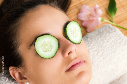 Woman with cucumber slices on eyes.