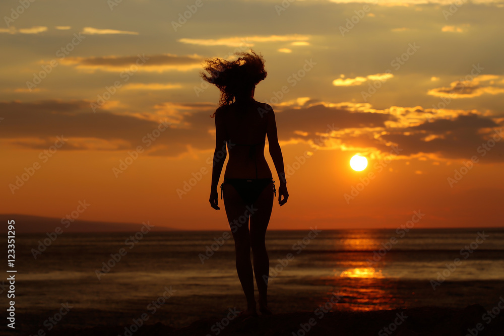 woman silhouette in sunset beach