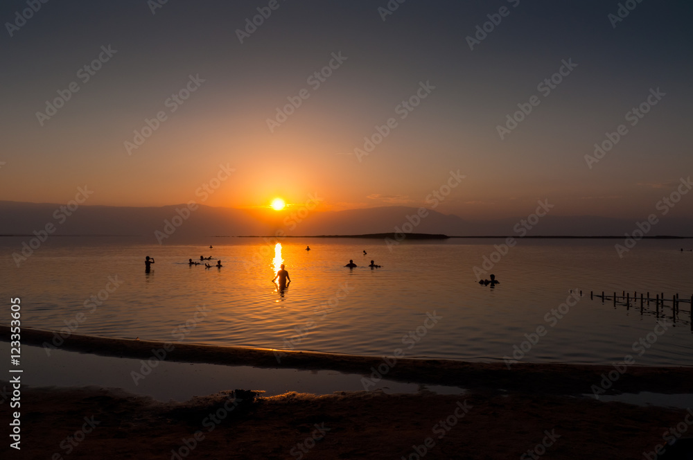 People floating at the Dead sea at dawn, Israel