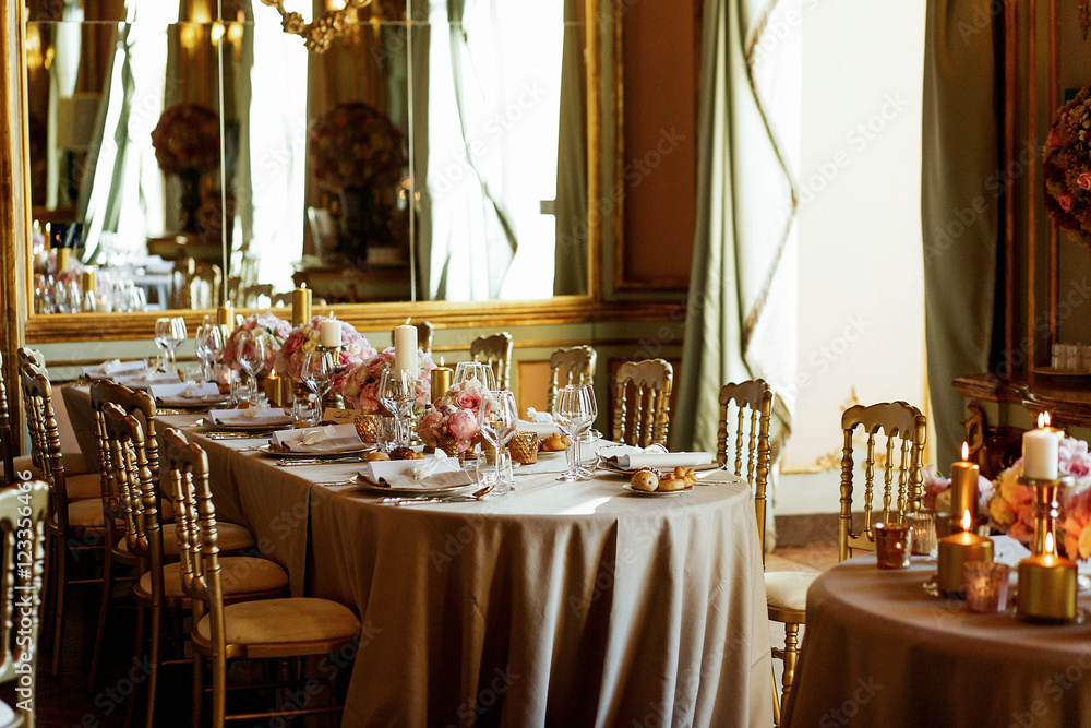 White daylight covers long dinner table served in golden and pin