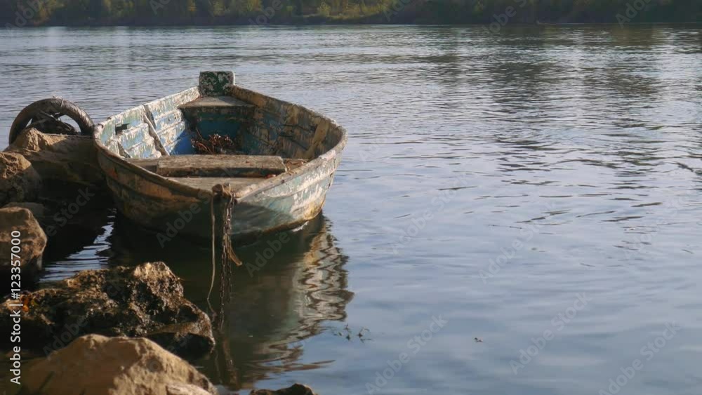 Old moored boat in a river, with trees on the other side
Old moored boat in a river, with trees on the other side