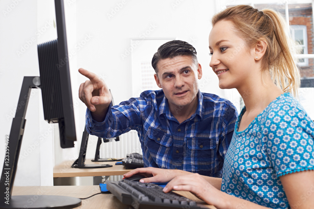 © highwaystarz - Man Training Woman On Computer In Office