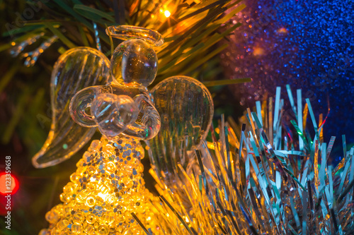 Christmas background. Christmas Angel made of glass. The hands holding the heart.