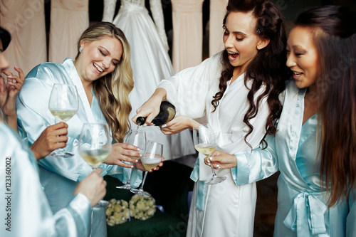Gorgeous women in silk robes pour champagne in glasses © IVASHstudio