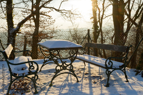 Table and benches covered with snow at a romantic spot in the pa