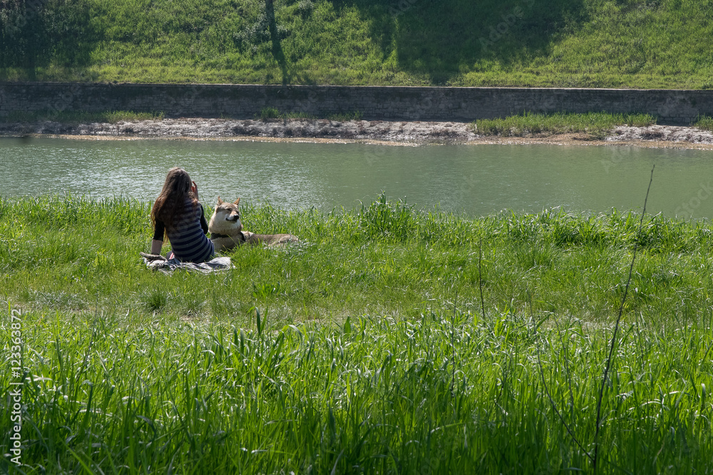 Ragazza sola in riva al fiume con il cane Ragazza sola in riva al fiume con il cane