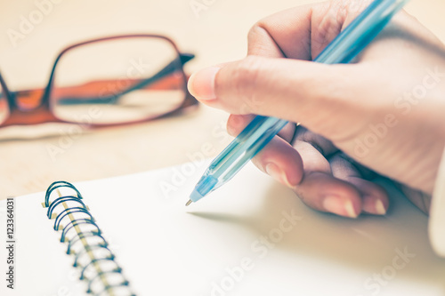 Business women hands working writing notebook on wooden desk  lighing effect