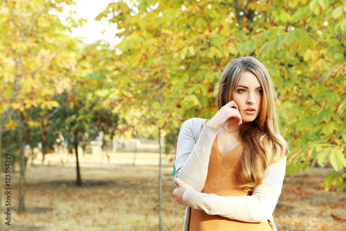 Beautiful young girl in autumn park, outdoors