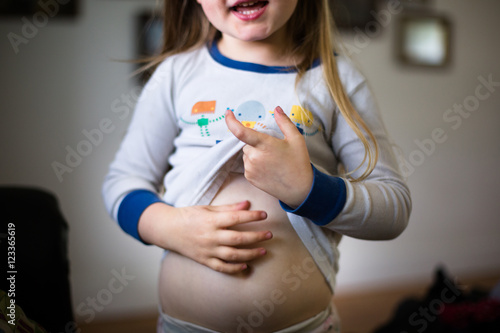 Young girl lifting top, showing belly, mid section