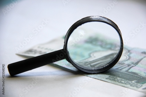 magnifying glass on money bill