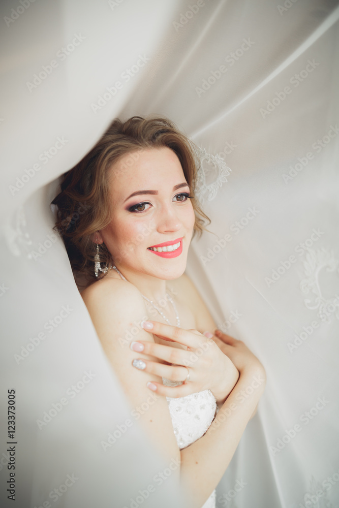 Luxury bride in white dress posing while preparing for the wedding ceremony Luxury bride in white dress posing while preparing for the wedding ceremony