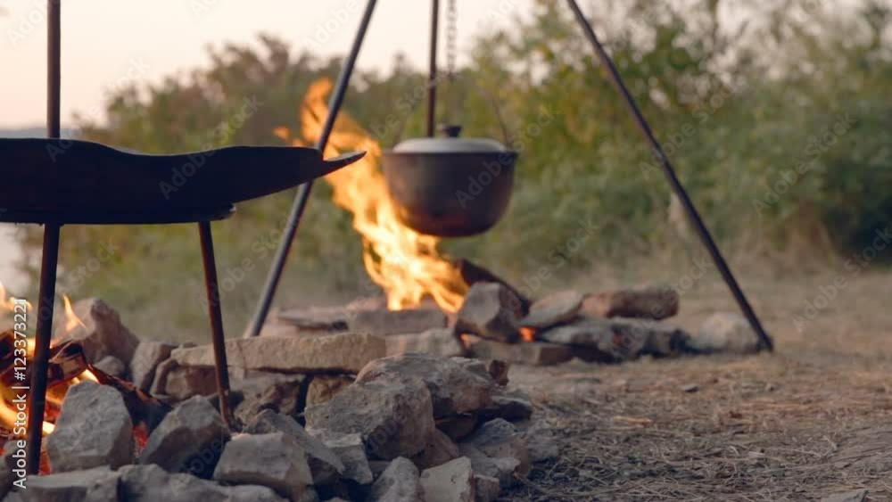 DOLLY MOTION: Cooking two dishes on fire. Food in the campaign. Journey to the wild forests to wildlife. Romantic trips. Travel Gear. Tourist pots on fire DOLLY MOTION: Cooking two dishes on fire. Food in the campaign. Journey to the wild forests to wildlife. Romantic trips. Travel Gear. Tourist pots on fire