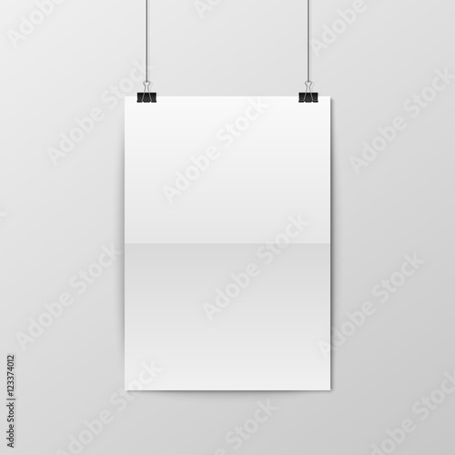 Sheet of folded paper hangs on the clamps.