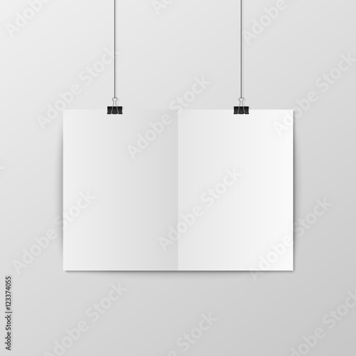 Sheet of folded paper hangs on the clamps.