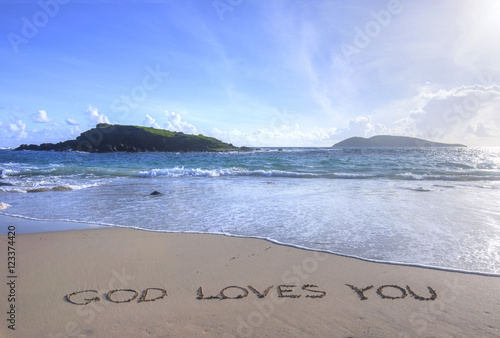 God Loves You written in sand on beach