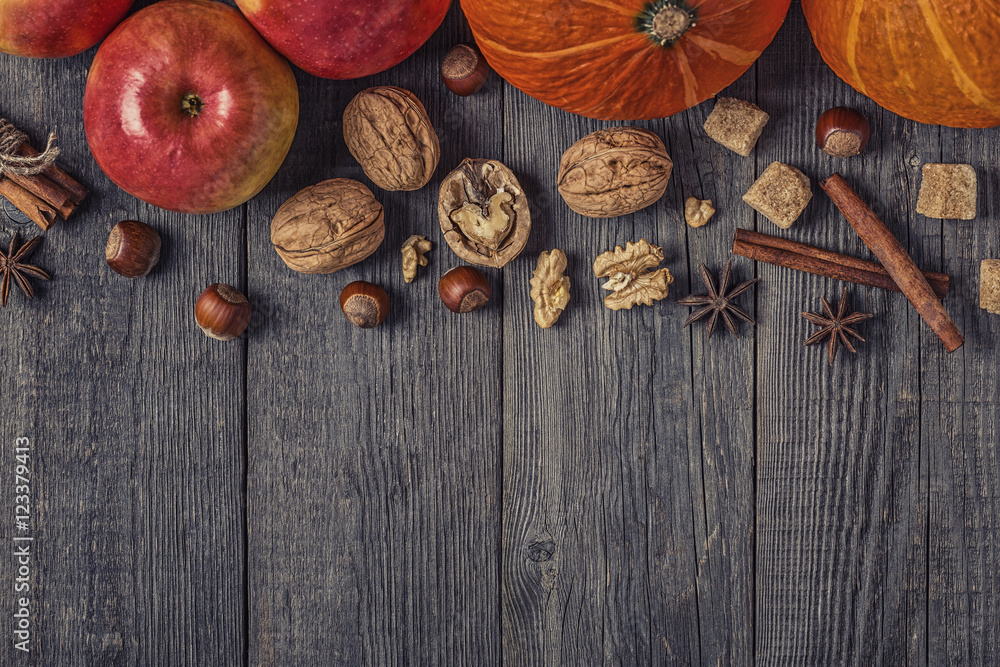 Wooden background with pumpkin, apples, nuts and spices. Wooden background with pumpkin, apples, nuts and spices.