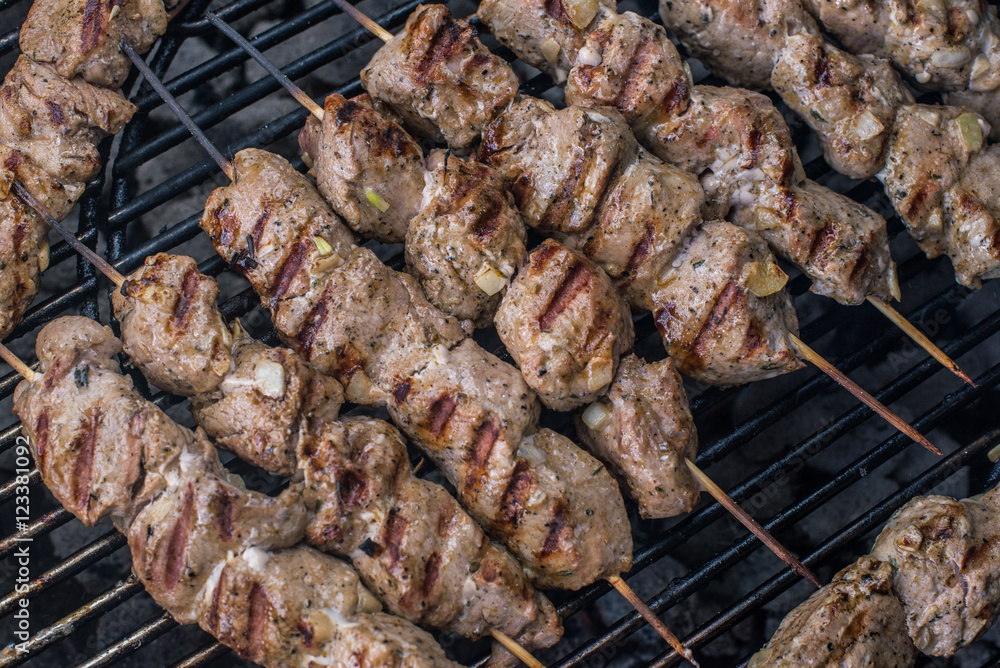 Barbecue photo: grilled meat (shashlik on bamboo skewers) fried on grill lattice