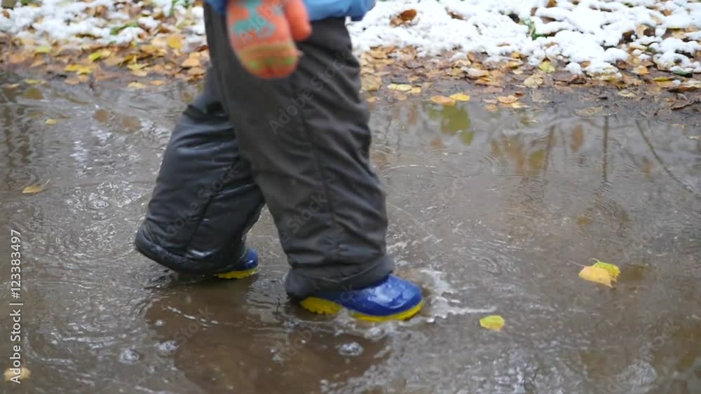 a child runs through puddles in autumn park a child runs through puddles in autumn park
