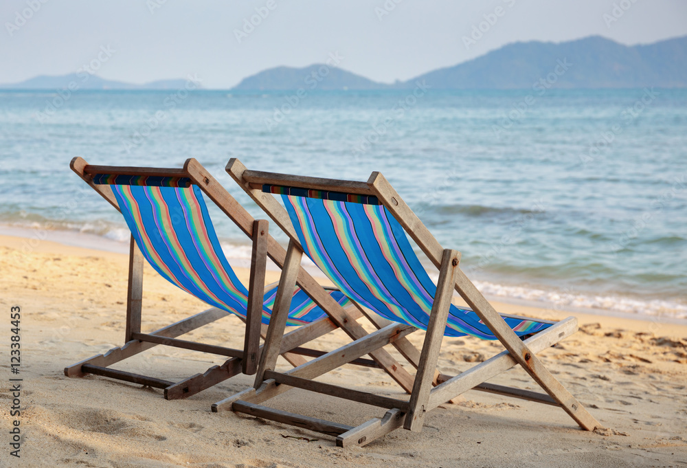 Two beach chairs on idyllic tropical beach.