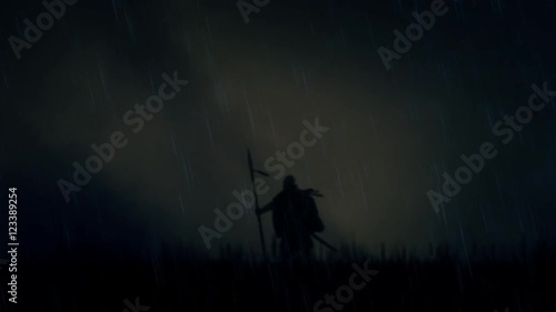 A Warrior Standing Alone in a Field Under Storm photo