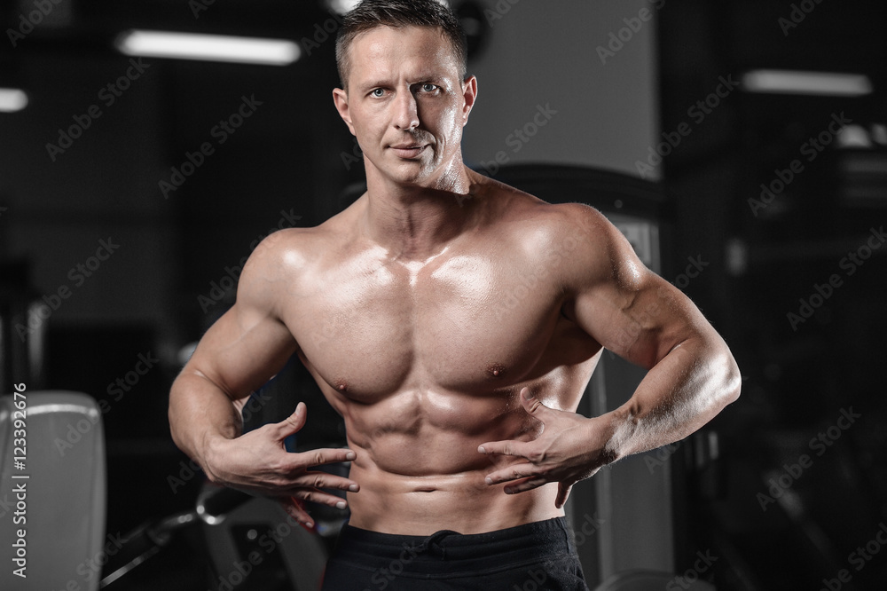 Handsome athletic fitness man posing and trains in the gym. Handsome athletic fitness man posing and trains in the gym.