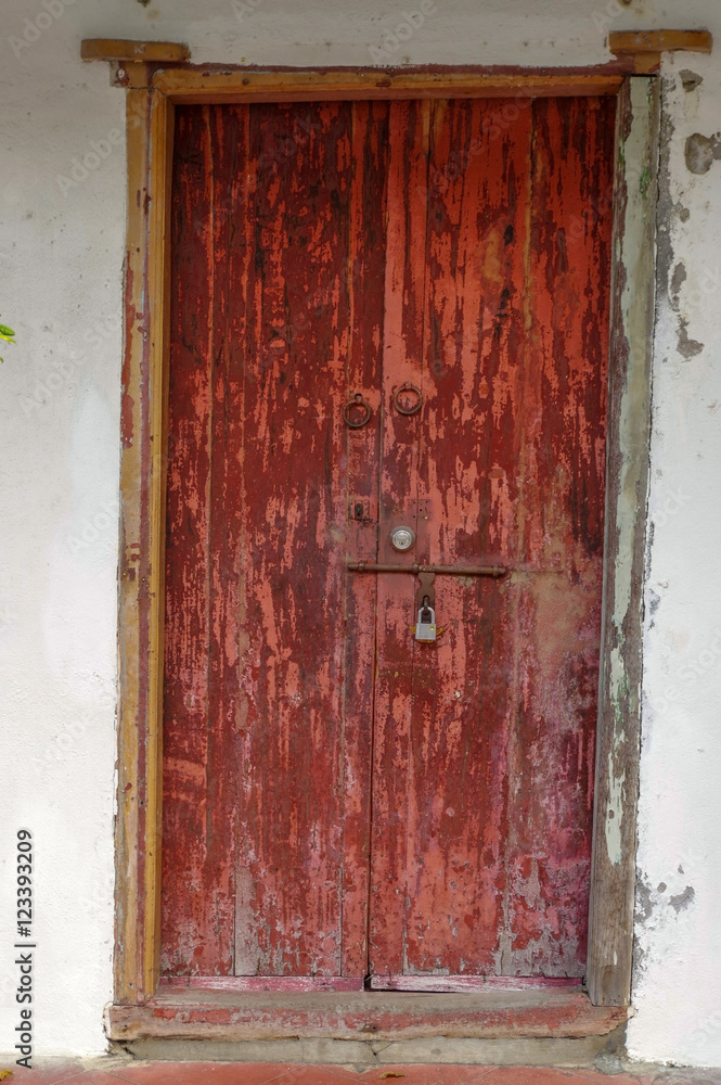 closed old red wooden door. Mediterranean style exterior.