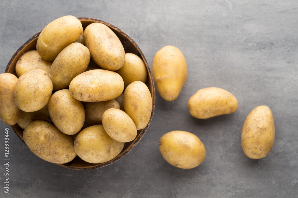 New potato on the bowl, gray background. New potato on the bowl, gray background.