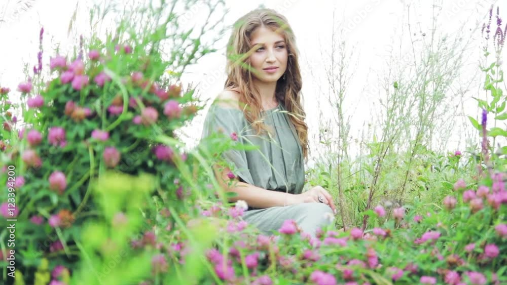 beautiful girl sitting in clover in nature, outdoors beautiful girl sitting in clover in nature, outdoors