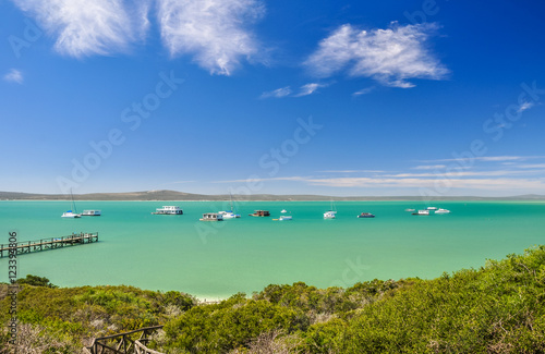 Stunning view of Langebaan Lagoon in West Coast National Park,120 km north of Cape Town, Western Cape Province, South Africa. Sunny day, house boats, a jetty and mountains in the background.