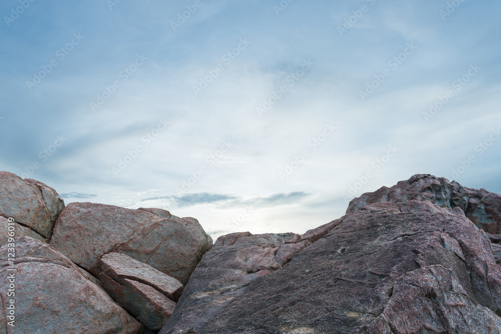 Pile of rocks boulders on sunset sky background