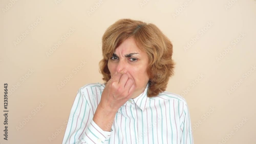 Woman holding her nose with her fingers because of bad smell Woman holding her nose with her fingers because of bad smell