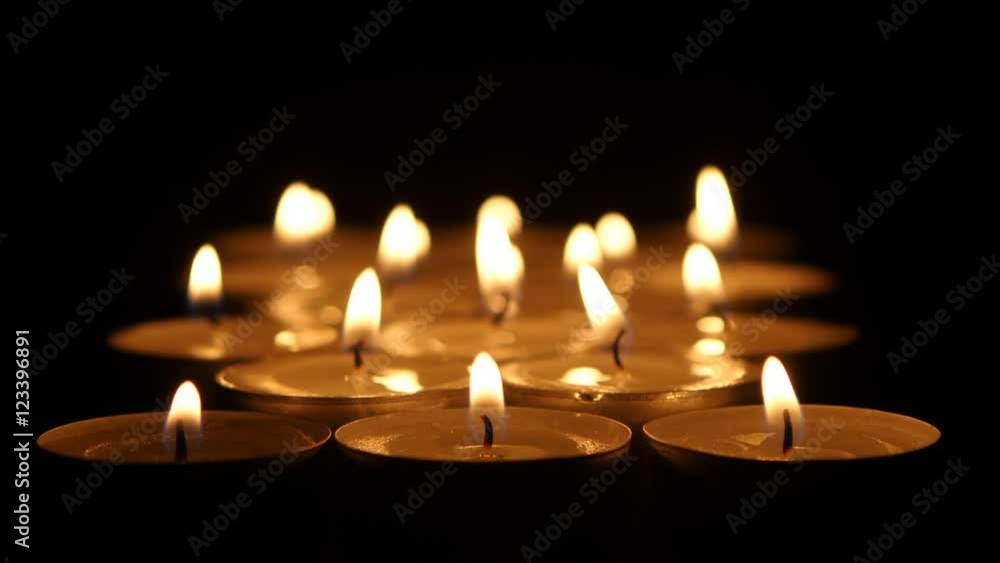 Group of burning candles on black background. Close up Group of burning candles on black background. Close up