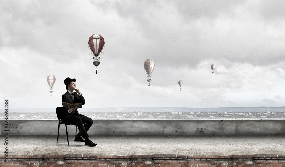 Elegant businessman read old book . Mixed media Elegant businessman read old book . Mixed media