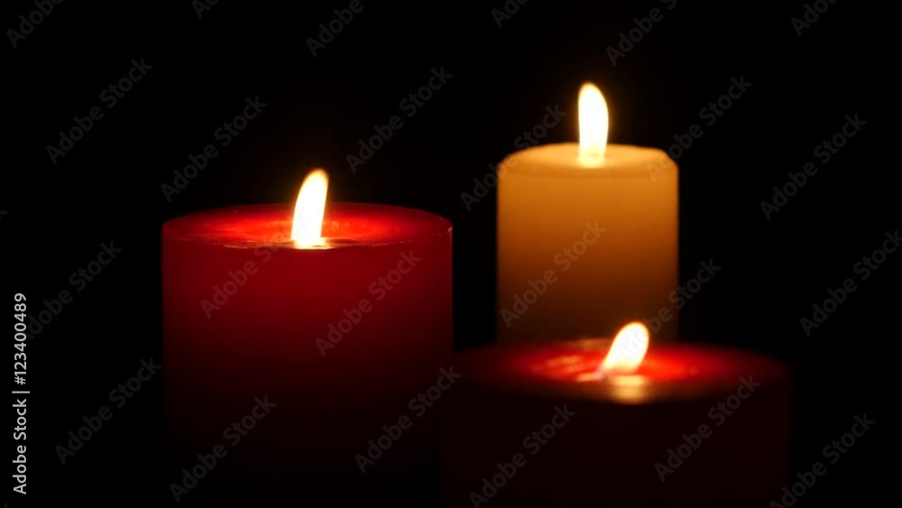 Three candles burning on a black background, Close up Three candles burning on a black background, Close up