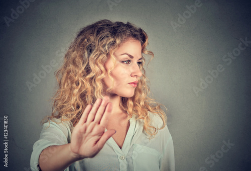 annoyed angry woman with bad attitude giving talk to hand gesture