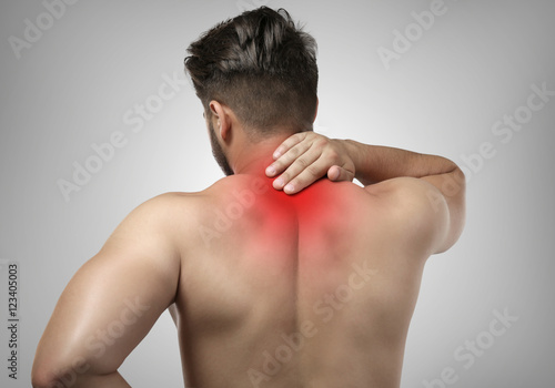 Man with neck pain on grey background